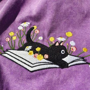 Cozy Cat on a Literary Adventure Embroidered T-shirt for Bookworms and Feline Enthusiasts