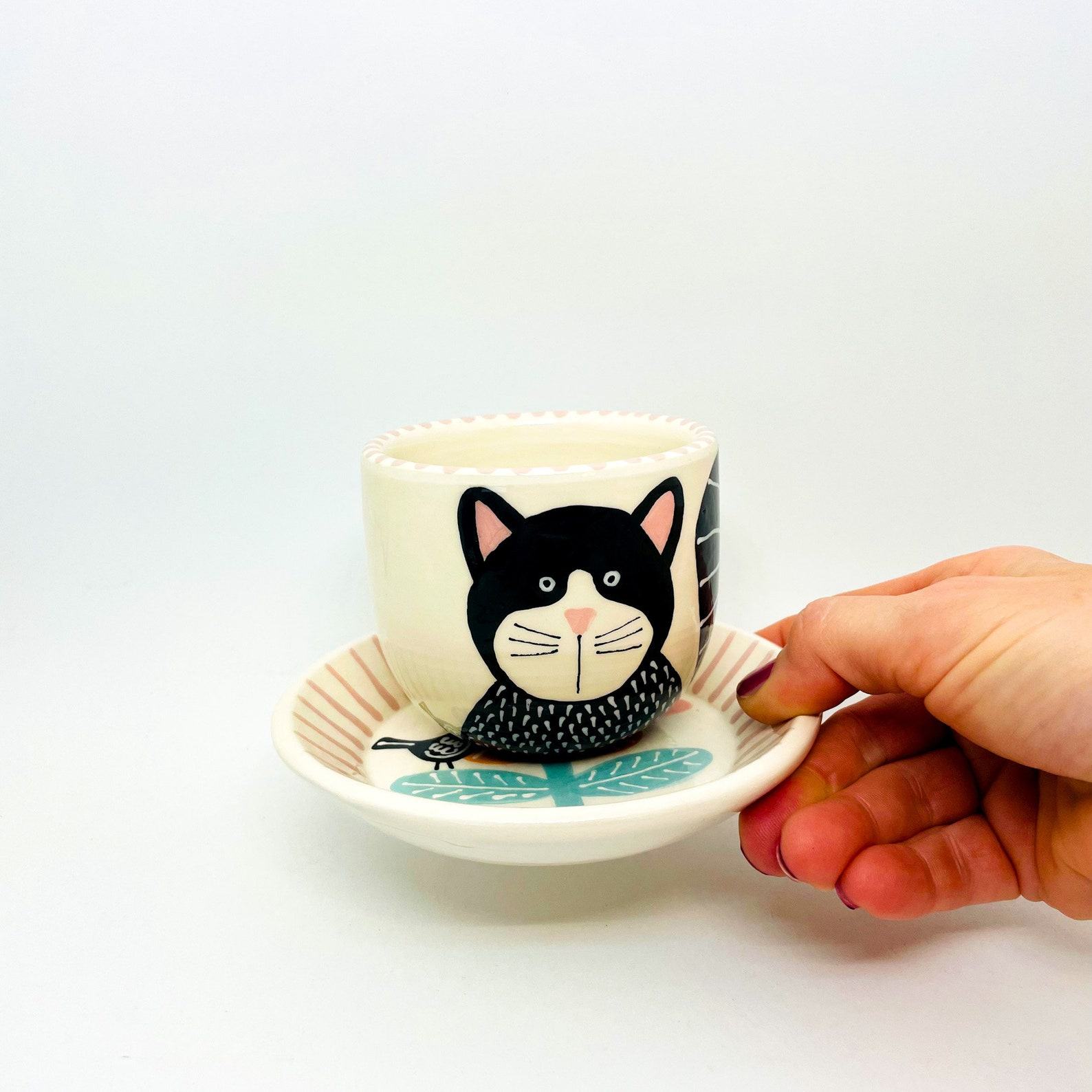 Enchanting Ceramic Cup and Saucer A Feline Fantasy with a Bird and Bloom